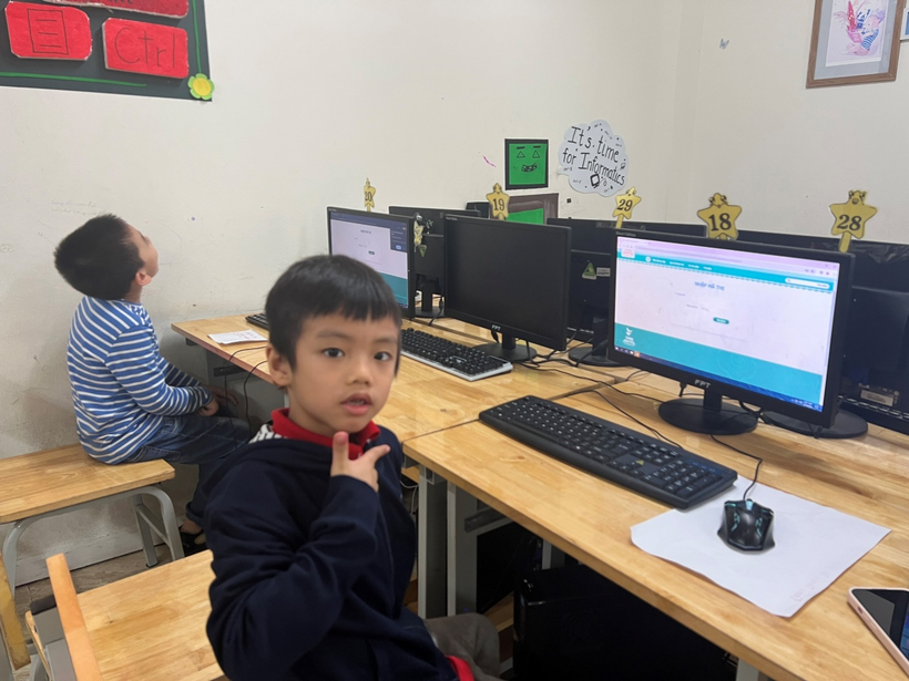 A child sitting at a desk with a computer

Description automatically generated